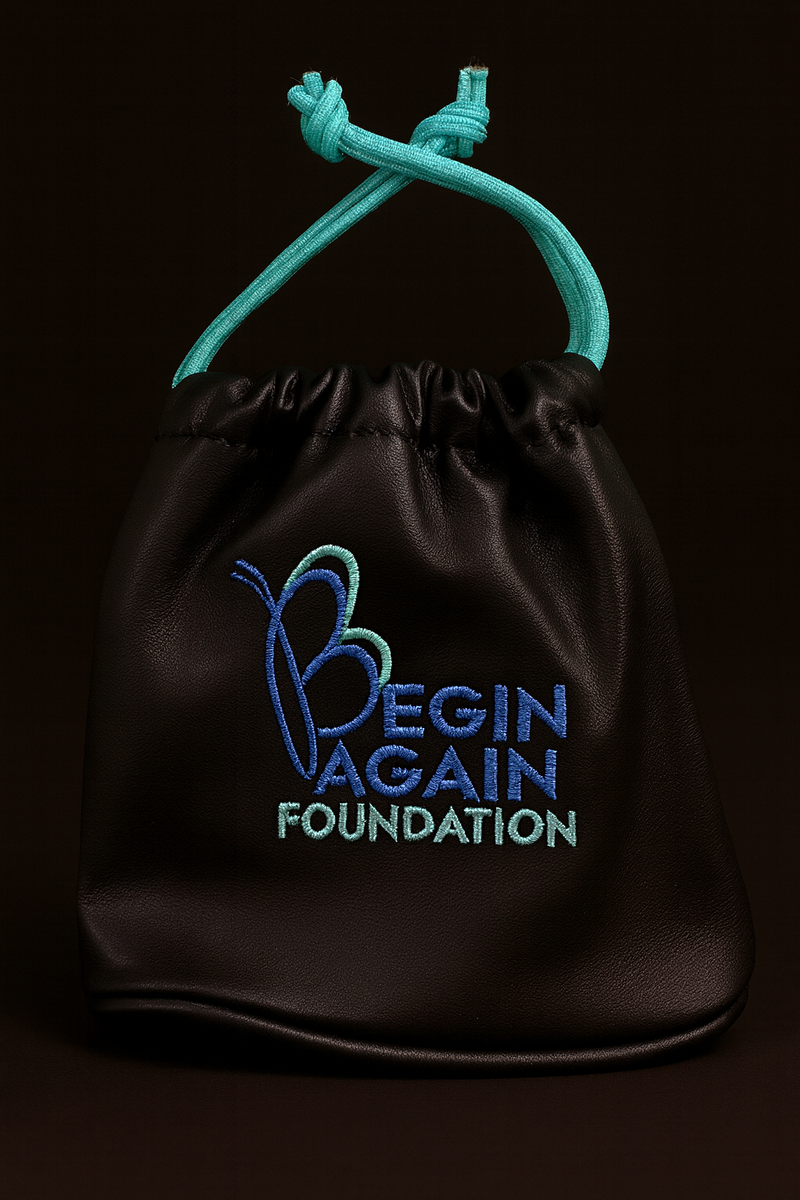 Black drawstring bag with 'Begin Again Foundation' text and logo on a black background