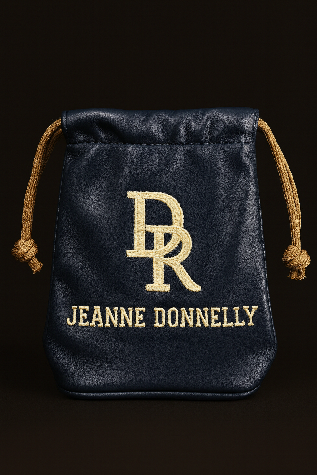 Black drawstring bag with gold logo and text on a black background