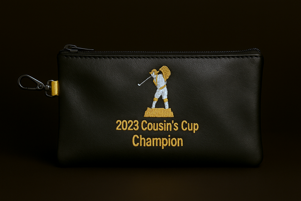 Black pouch with '2023 Cousin's Cup Champion' text and logo on a dark background